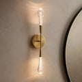 Gold wall sconce with a round mirror on a beige wall