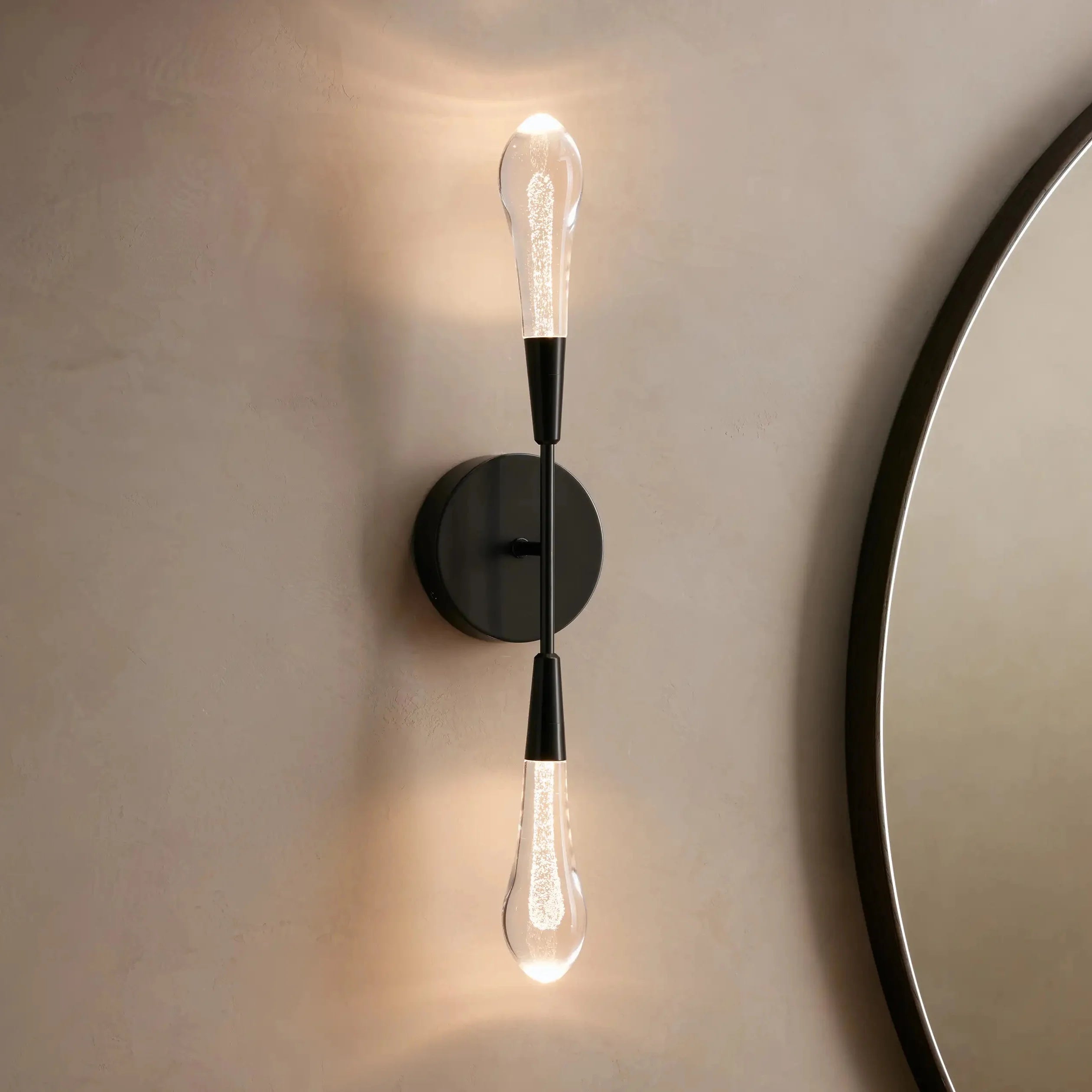 Modern wall sconce with two light bulbs on a neutral wall.