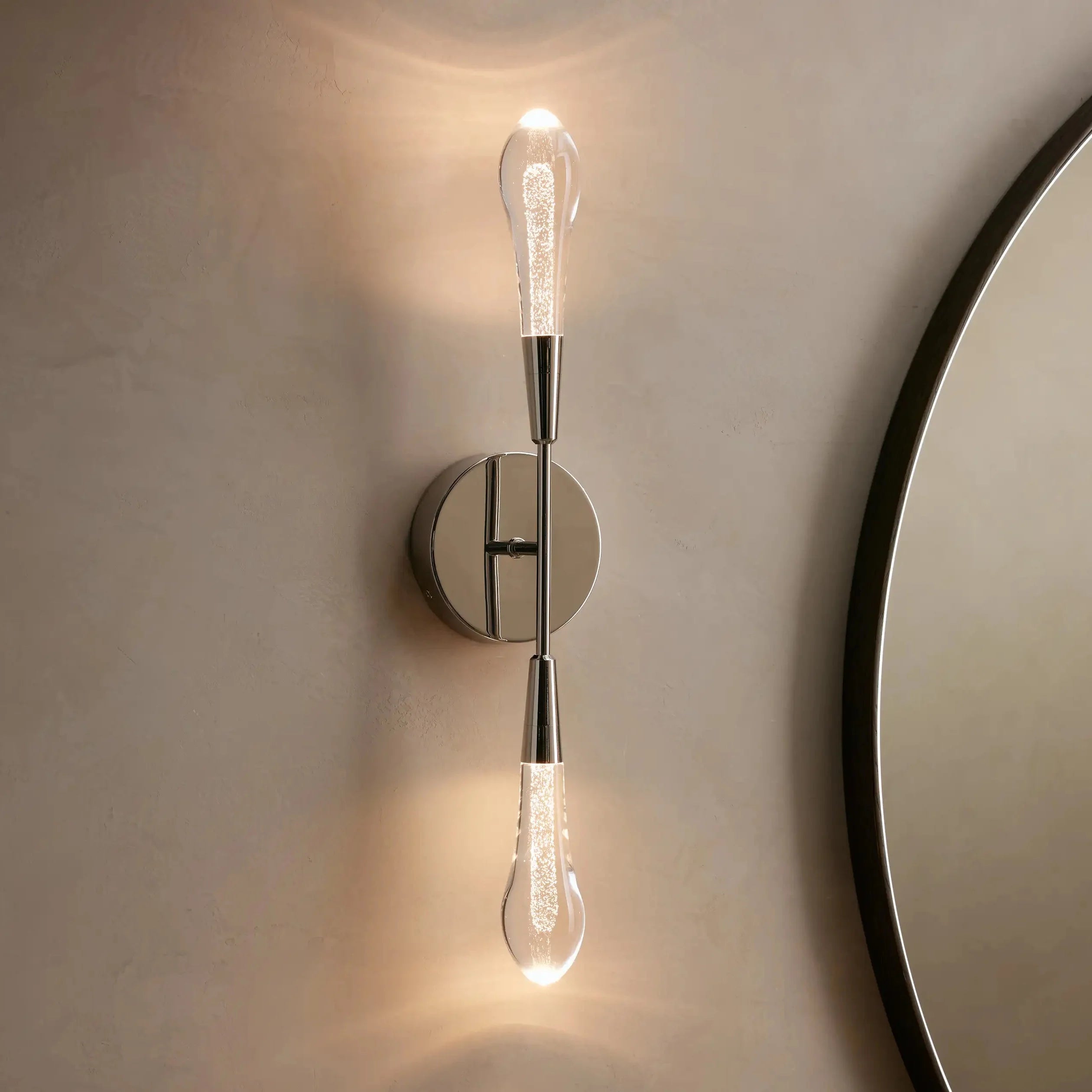 Modern wall sconce with a round mirror on a neutral wall