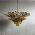 Amber glass Palmette chandelier shown in a compact studio view on a gray wall.