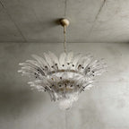 Clear glass Palmette chandelier shown in a compact studio view on a gray wall.