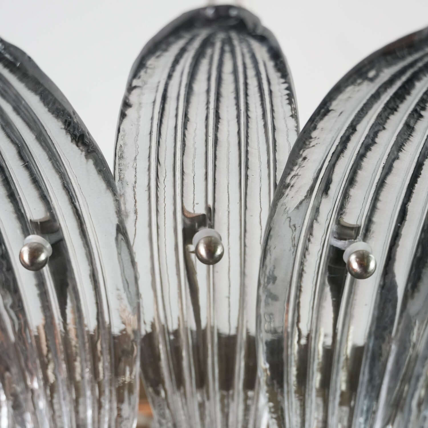 Close-up of clear ribbed glass leaves on the Murano Palmette chandelier.