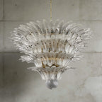 Clear glass Palmette chandelier shown in a large tiered studio view on a gray wall.