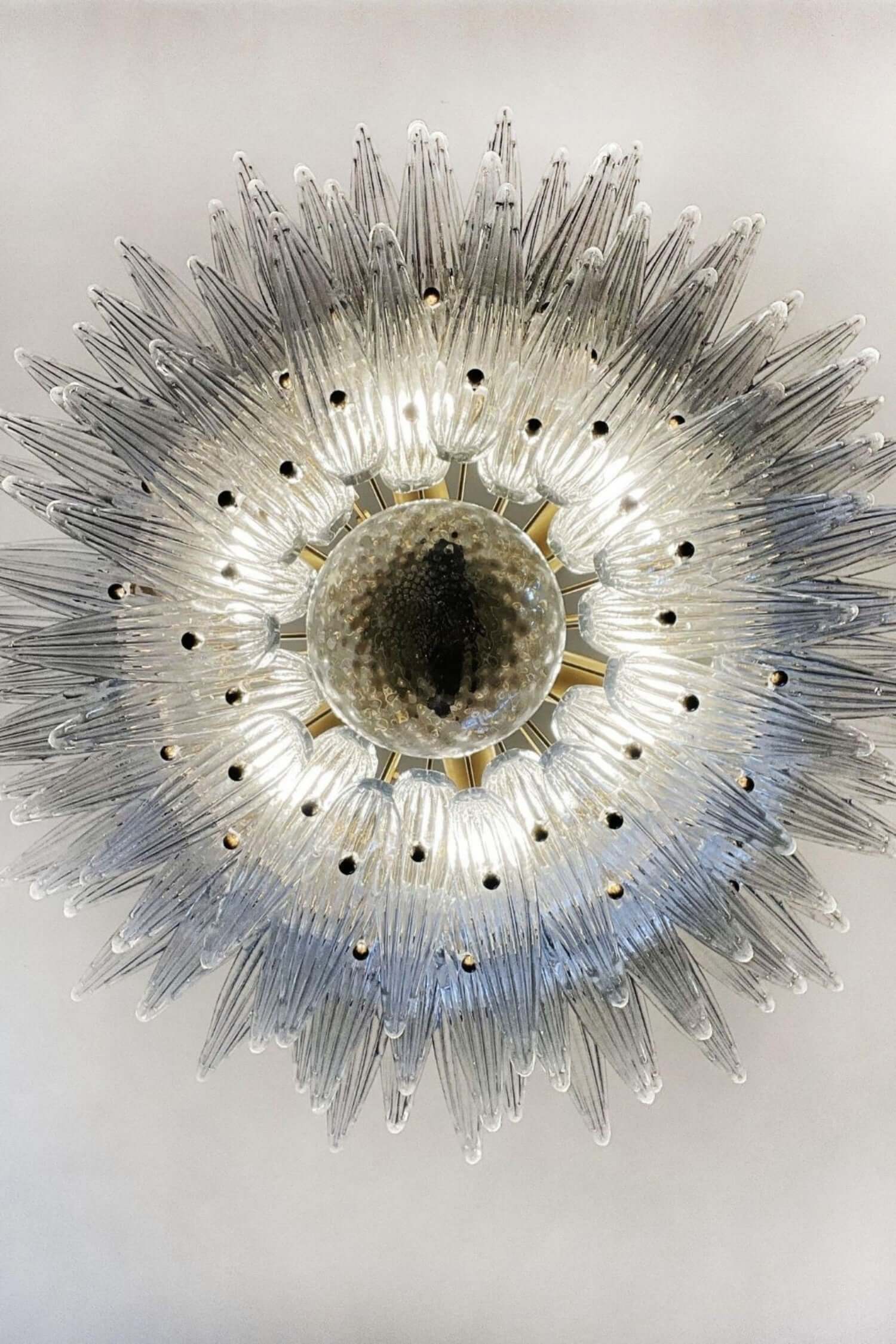 Underside view of the clear glass Palmette chandelier with layered leaves.