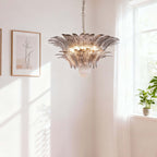 Pink glass chandelier hanging near a bright corner wall and window.
