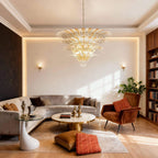 Clear glass Palmette chandelier above a living room seating area with a sofa.