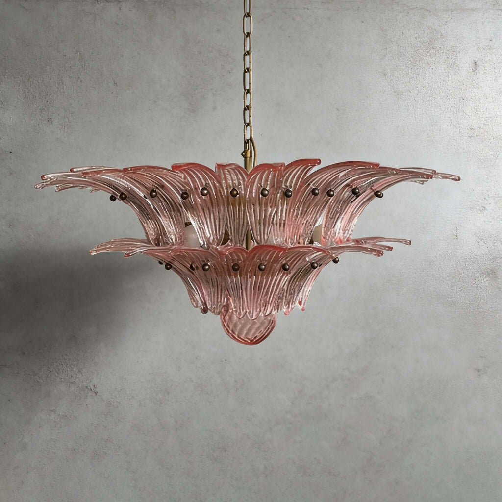 Pink glass Palmette chandelier shown in a compact studio view on a gray wall.