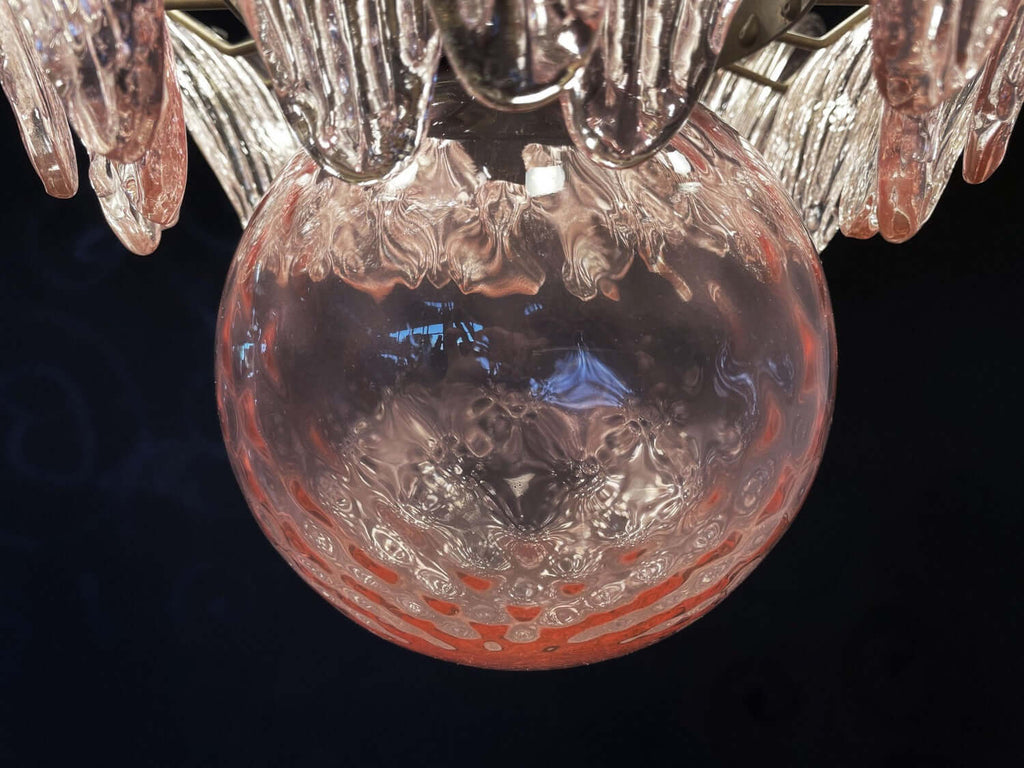 Close-up of the pink glass globe and clear leaf shades on the chandelier.