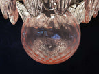 Close-up of the pink glass globe and clear leaf shades on the chandelier.