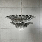 Smoky gray glass Palmette chandelier shown in a compact studio view on a gray wall.