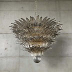 Smoky gray glass Palmette chandelier shown in a large tiered studio view on a gray wall.