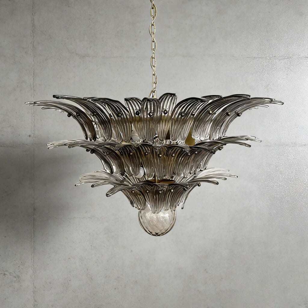 Smoky gray glass Palmette chandelier shown in a wider studio view on a gray wall.