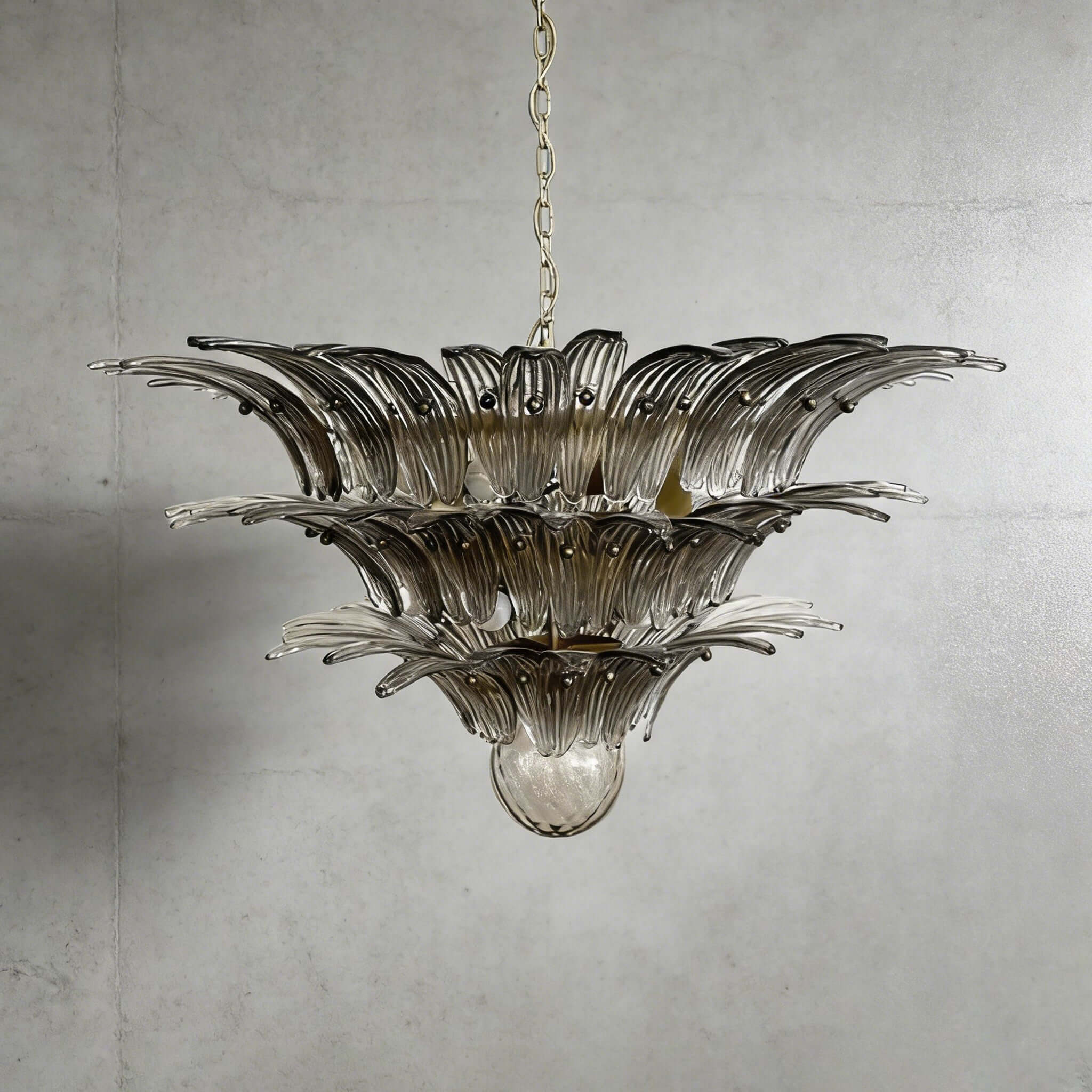 Smoky gray glass Palmette chandelier shown in a wider studio view on a gray wall.