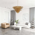 Amber glass chandelier above a white modern living room with low seating.