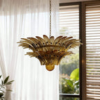 Amber glass chandelier shown close near sheer curtains and a window.